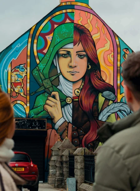 A couple admires colourful street art on a building in Dundalk.