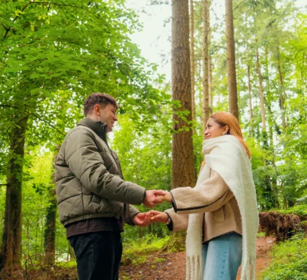 A couple holding hands on a forest path near The Gateway Hotel Dundalk.