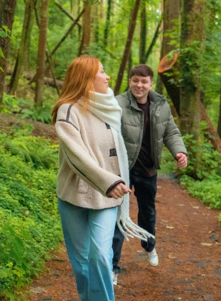 A couple enjoys a walk through lush green forests near The Gateway Hotel Dundalk.