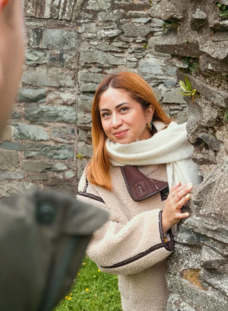 Couple enjoying a moment by a historic stone wall at The Gateway Hotel, Dundalk.
