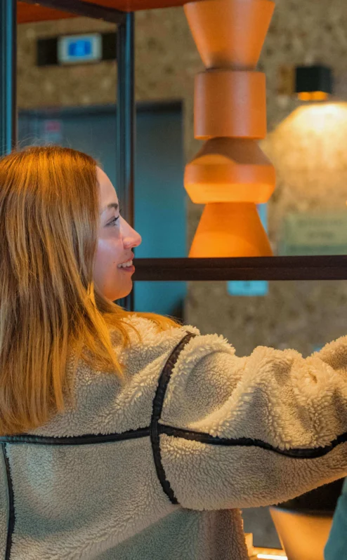 A couple enjoys browsing books in The Gateway Hotel lobby's cosy, warmly-lit setting.