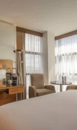 Spacious hotel room with king-sized bed, seating area, and large windows at The Gateway Hotel Dundalk.