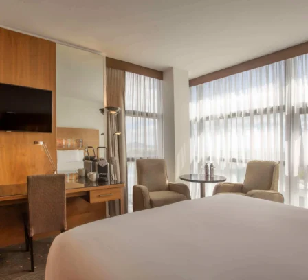 Spacious hotel room with king-sized bed, seating area, and large windows at The Gateway Hotel Dundalk.