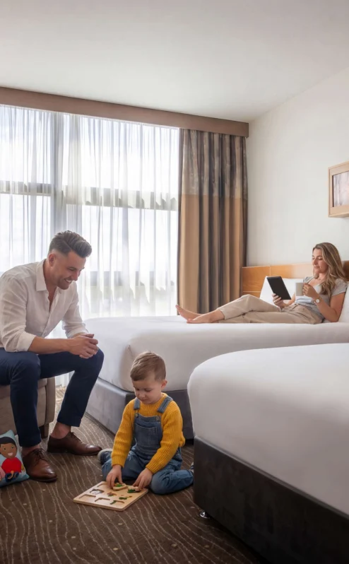 Family relaxing in a modern hotel room; child playing, parents unwinding.