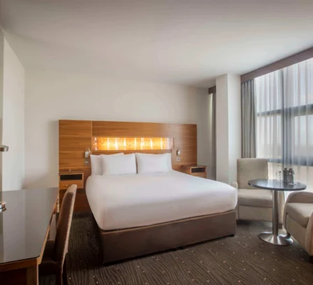 Spacious hotel room with a cosy double bed, desk, and seating area at The Gateway Hotel Dundalk.