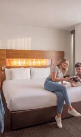 Couple leisurely enjoying a bright, modern hotel room at The Gateway Hotel Dundalk.