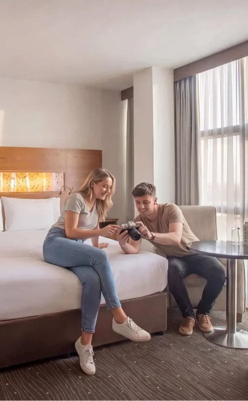 Couple leisurely enjoying a bright, modern hotel room at The Gateway Hotel Dundalk.