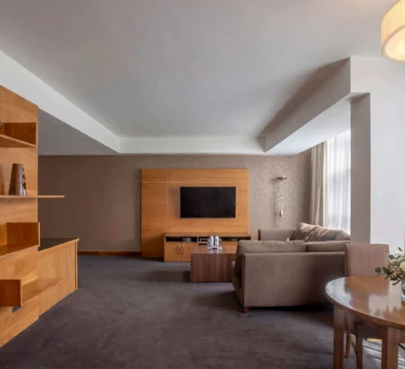 Spacious hotel suite with modern decor, cosy seating area, and natural light.