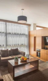 Spacious hotel suite with modern decor, cosy seating, and large windows at The Gateway Hotel.