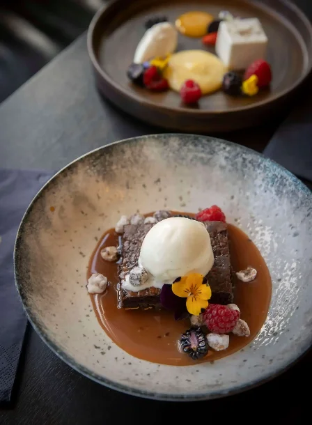 Decadent desserts with berries and ice cream at The Gateway Hotel's restaurant.
