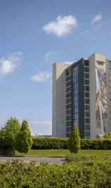 A family enjoys sunny outdoors near The Gateway Hotel Dundalk with lush greenery around.