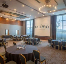 Spacious hotel meeting room with round tables and large windows at The Gateway Hotel.