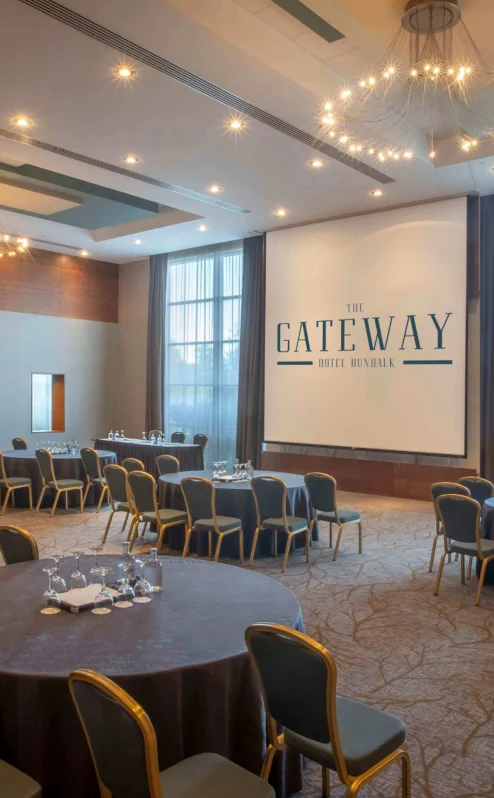 Spacious hotel meeting room with round tables and large windows at The Gateway Hotel.