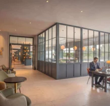 Spacious hotel lounge with a family enjoying comfortable seating, modern décor, and large windows.