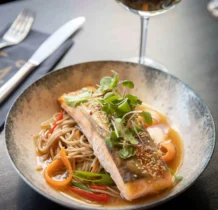 Elegant salmon dish with noodles and vegetables at The Gateway Hotel.