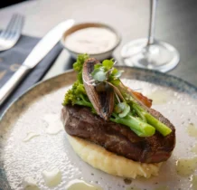 A delectable steak dish with vegetables at The Gateway Hotel restaurant, elegantly presented.