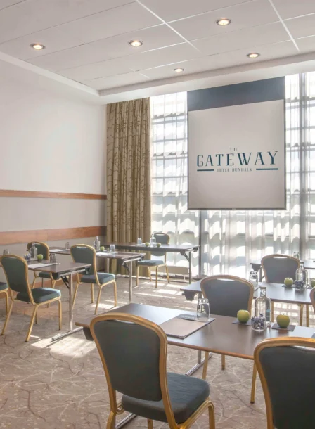Bright meeting room in The Gateway Hotel Dundalk with tables set for a business event.