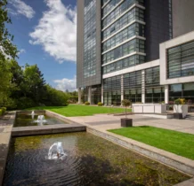 Family enjoying the garden area of The Gateway Hotel Dundalk with fountains and greenery.