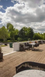 Family enjoying sunny day on hotel terrace with lush greenery and modern decor.