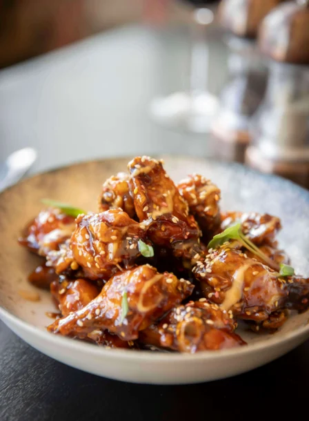 Savoury glazed chicken wings at The Gateway Hotel dining table.