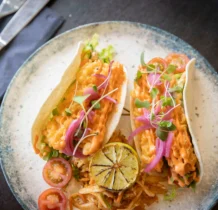 Delicious tacos with vibrant toppings and lime at The Gateway Hotel restaurant.