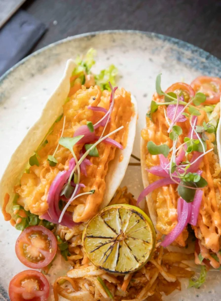 Delicious tacos with vibrant toppings and lime at The Gateway Hotel restaurant.
