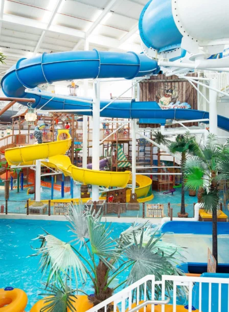 Family enjoying colourful indoor waterpark with slides, pools and tropical décor at The Gateway Hotel (visible sign: "Pirates Cove")