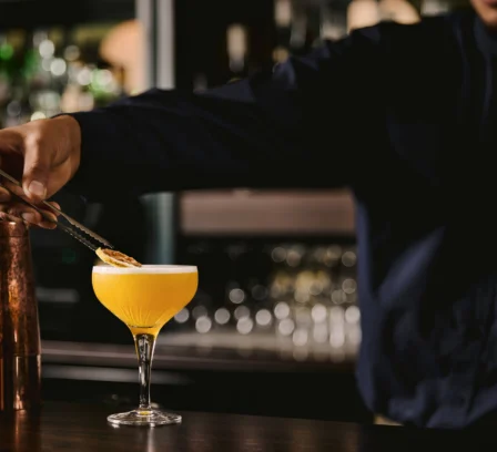 Bartender garnishing a cocktail at The Gateway Hotel bar.