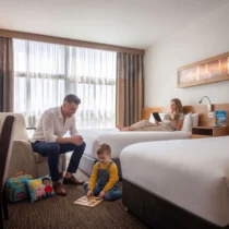 Family enjoying a cosy hotel room; child plays, parents relax with views of Dundalk.