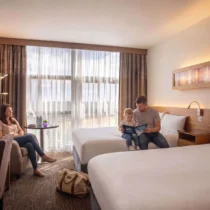 A family relaxing in a cosy hotel room with large windows at The Gateway Hotel, Dundalk.