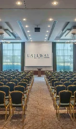 Spacious conference room at The Gateway Hotel with rows of chairs facing a podium.