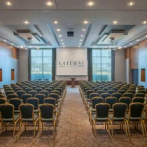 Spacious conference room at The Gateway Hotel with rows of chairs facing a podium.