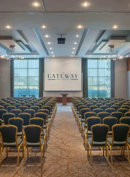 Spacious conference room at The Gateway Hotel with rows of chairs facing a podium.