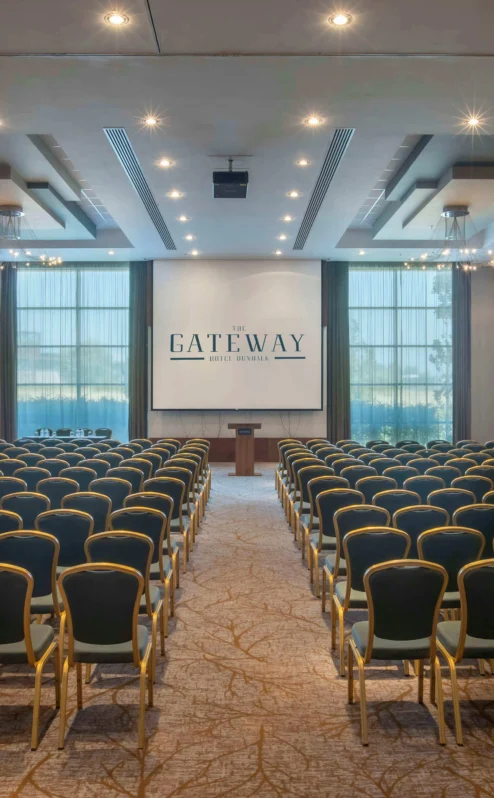 Spacious conference room at The Gateway Hotel with rows of chairs facing a podium.