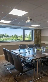 Modern meeting room at The Gateway Hotel with a scenic garden view from the window.