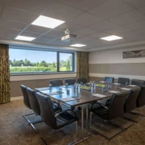 Modern meeting room at The Gateway Hotel with a scenic garden view from the window.