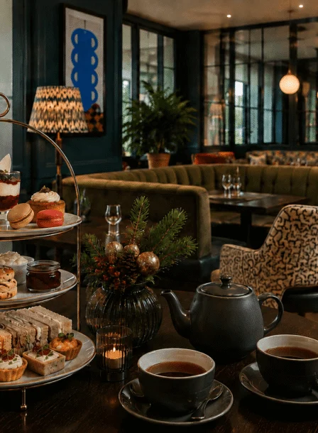Family enjoying afternoon tea with pastries at The Gateway Hotel lounge.