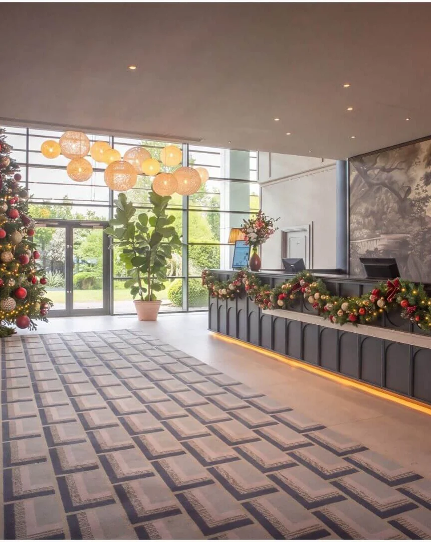 Festively decorated hotel lobby with family-friendly seating, Christmas tree and welcoming reception desk
